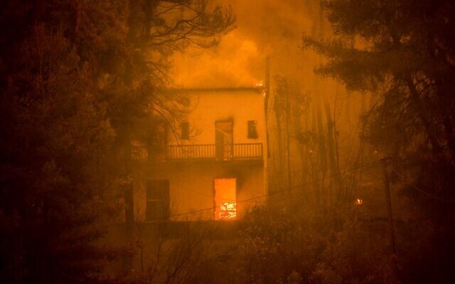 Uma casa está pegando fogo enquanto incêndios florestais se aproximam da aldeia de Pefki na ilha de Evia (Eubeia), a segunda maior ilha da Grécia, em 8 de agosto de 2021. Centenas de bombeiros gregos lutaram desesperadamente em 8 de agosto para controlar incêndios florestais na ilha de Evia que queimaram vastas áreas de floresta de pinheiros destruíram casas e forçaram os turistas e habitantes locais a fugir. Grécia e Turquia lutam contra incêndios devastadores há quase duas semanas, enquanto a região sofreu sua pior onda de calor em décadas, que os especialistas relacionam à mudança climática. (Angelos Tzortzinis / AFP)