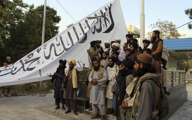 Combatentes do Taleban posam para uma fotografia enquanto hasteavam sua bandeira na casa do governador da província de Ghazni, em Ghazni, sudeste do Afeganistão, em 15 de agosto de 2021. (AP Photo / Gulabuddin Amiri)