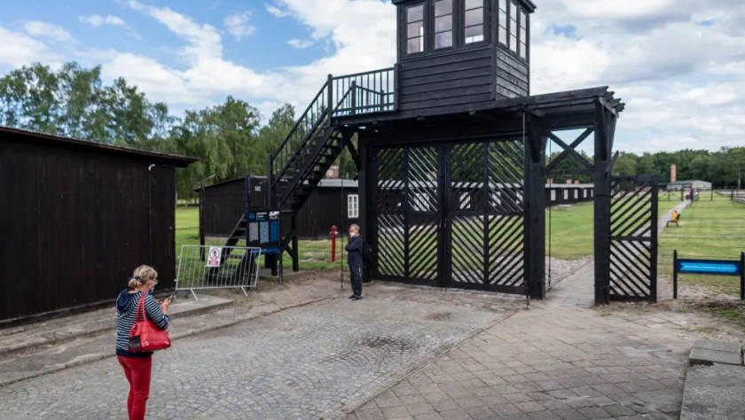 Pessoas em frente ao chamado 'Portão da Morte' enquanto visitam o museu no antigo campo de extermínio nazista de Stutthof, em Sztutowo, Polônia, 21 de julho de 2020. (Wojtek RADWANSKI / AFP)