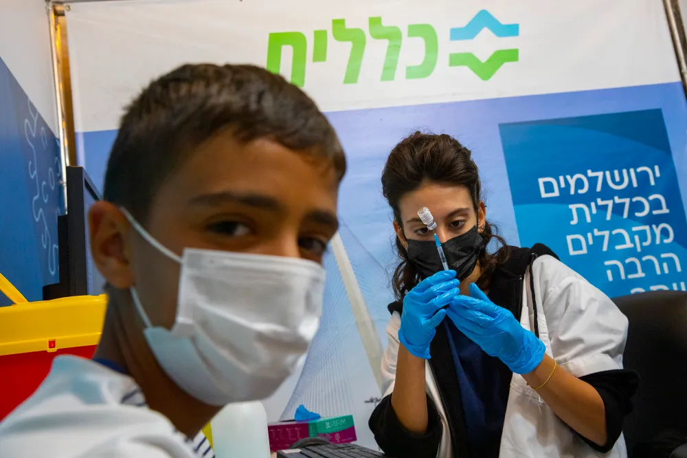 Os israelenses recebem sua terceira dose da vacina Covid-19 em uma organização de manutenção de saúde Clalit, em 20 de setembro de 2021 em Jerusalém. (Olivier Fitoussi / Flash90)