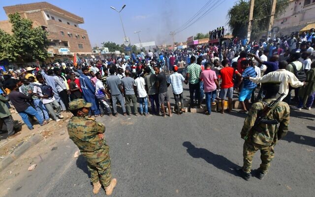 Forças de segurança sudanesas vigiam os protestos contra um golpe militar que anulou a transição para o regime civil, em 25 de outubro de 2021, na cidade gêmea de Omdurman, capital de Cartum. (AFP)