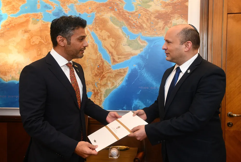 Primeiro Ministro israelense Naftali Bennett, à direita, recebendo um convite para visitar os Emirados Árabes Unidos do Embaixador dos Emirados Árabes Unidos em Israel, Mohamed Al Khaja, 19 de outubro de 2021 (HAIM ZACH / GPO)