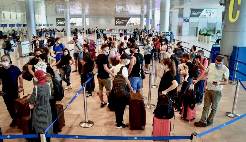 Os viajantes usam máscaras faciais de proteção no Terminal 3 do Aeroporto Internacional Ben Gurion, já que Israel restringe mais as viagens aéreas, em 5 de agosto de 2021. (crédito da foto: Avshalom Sassoni | Flash90)