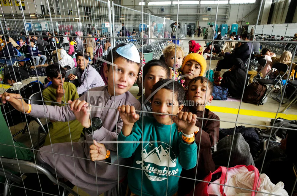 Crianças do Afeganistão esperam com outros evacuados para voar para os Estados Unidos ou outro local seguro em um portão de embarque improvisado dentro de um hangar na Base Aérea dos EUA em Ramstein, Alemanha, 1º de setembro de 2021 (AP Photo / Markus Schreiber)