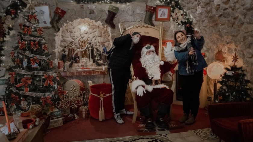 Issa Kassissieh, o tradicional Papai Noel da Terra Santa, diverte alguns visitantes em sua oficina esta semana.Crédito...Amit Elkayam para The New York Times